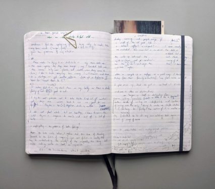 double spread of a notebook showing handwriting and bookmark