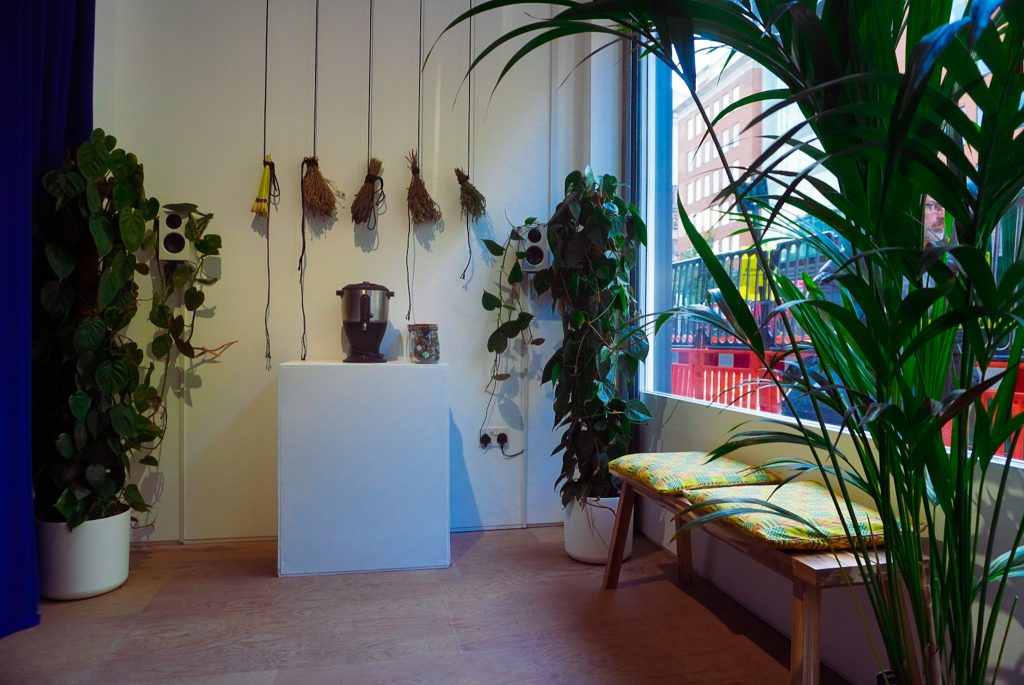 dried herbs hanging on the wall and a a tea urn by the gallery window.